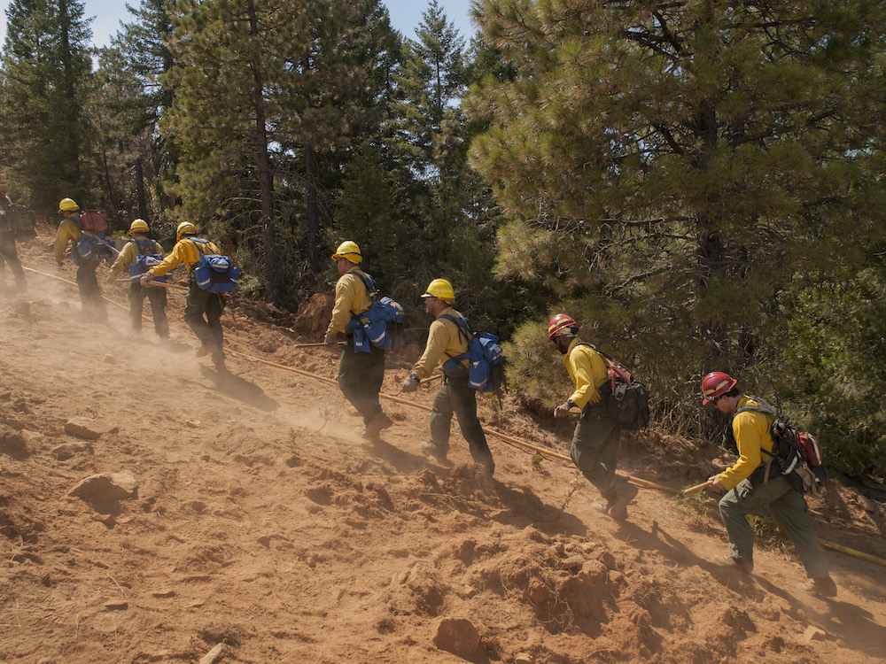 A hand crew hikes up the fireline.